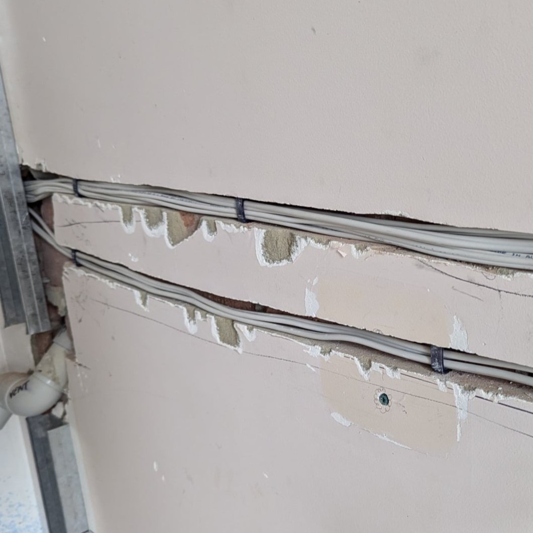 Chased wall channels with utility lines retained by ChaseMate, ready for plastering